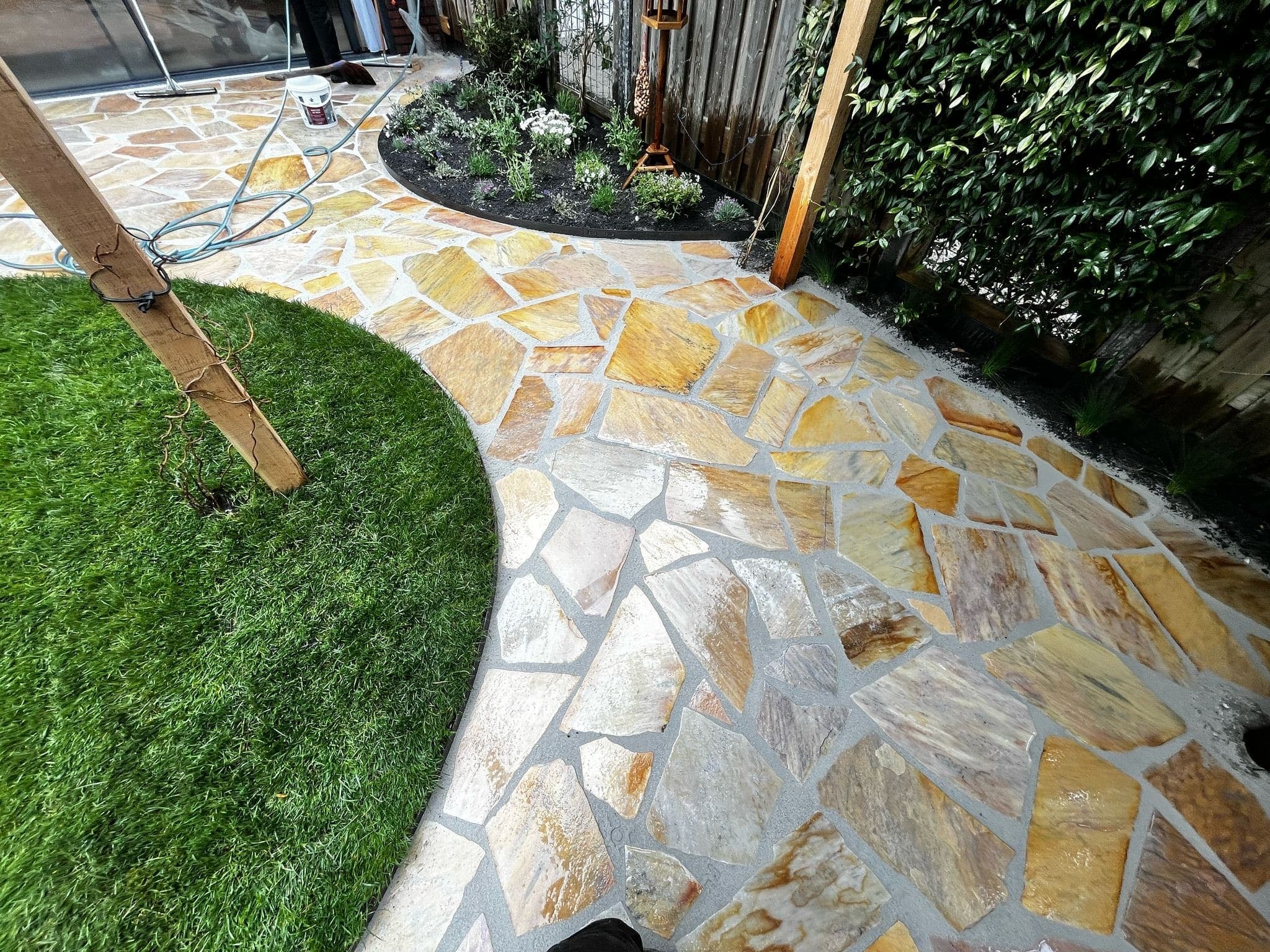 Natuursteen flagstone-bestrating langs een gazon