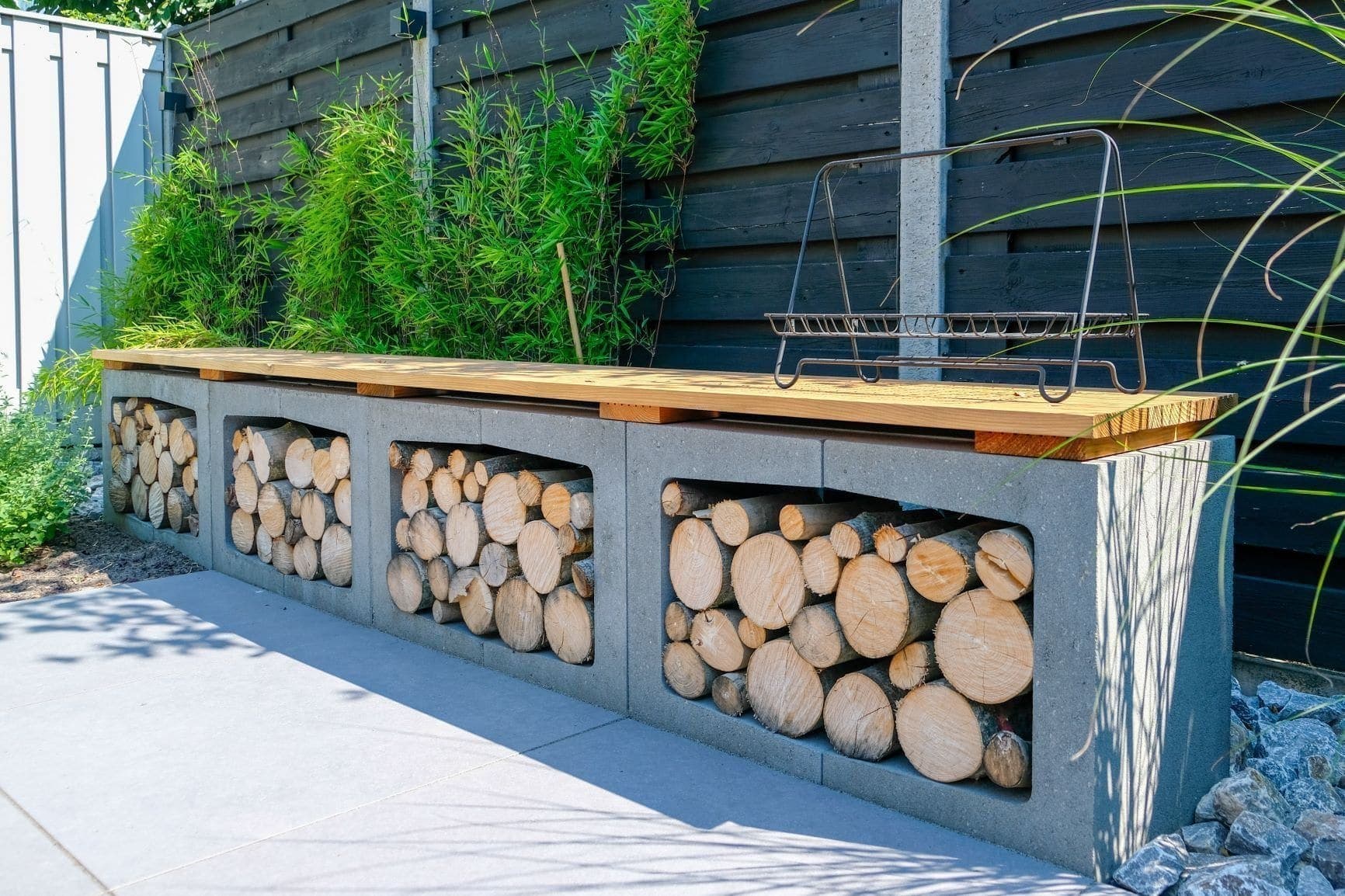 U-elementen van beton met haardhout als tuinmuur en zitbank