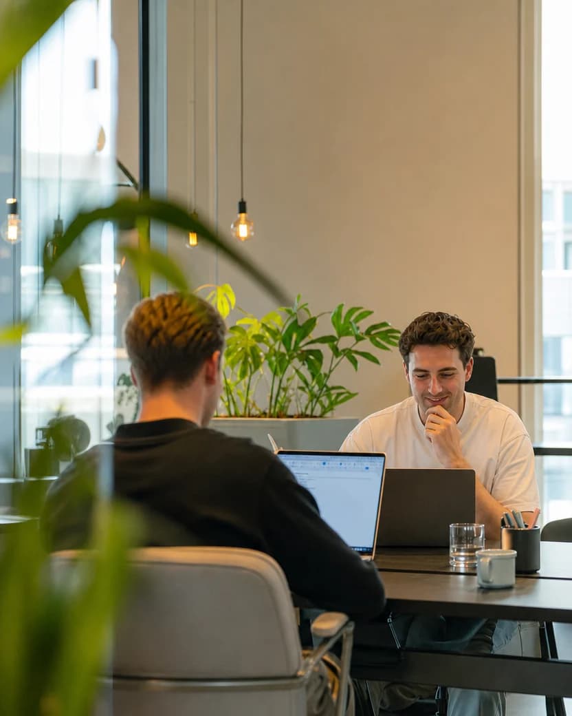 Twee collega's in gesprek op kantoor